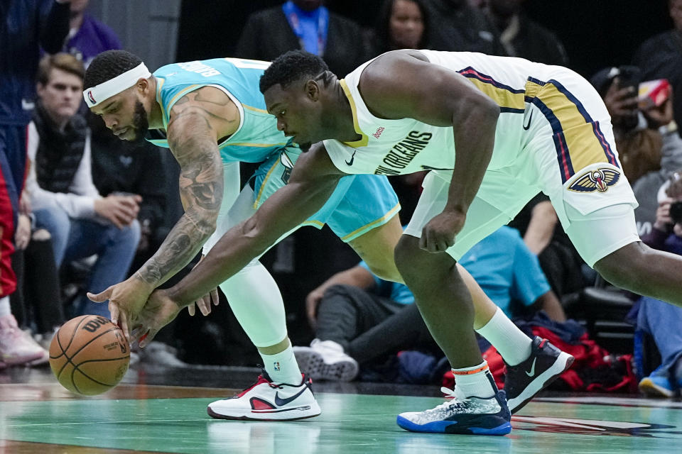 Charlotte Hornets forward Miles Bridges, left, vies for the ball with New Orleans Pelicans forward Zion Williamson during the first half of an NBA basketball game Friday, Dec. 15, 2023, in Charlotte, N.C. (AP Photo/Chris Carlson)