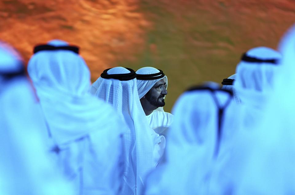 FILE - In this Wednesday, May 6, 2015, file photo, UAE Vice President and Prime Minister and ruler of Dubai, Sheikh Mohammed bin Rashid Al Maktoum, center, talks to Emirati officials after announcing a UAE Mars mission named "Hope" or "al-Amal" in Arabic, which is scheduled be launched in 2020, during a ceremony in Dubai, United Arab Emirates. Sheikh Mohammed bin Rashid Al Maktoum, made the announcement on Twitter that his country plans to send an unmanned spacecraft to the moon in 2024. (AP Photo/Kamran Jebreili, File)