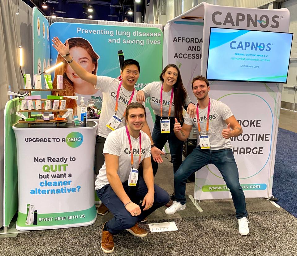 Brendan Wang, a 2022 graduate of Michigan State University and the founder and CEO of CAPNOS, with his staff at a trade show.