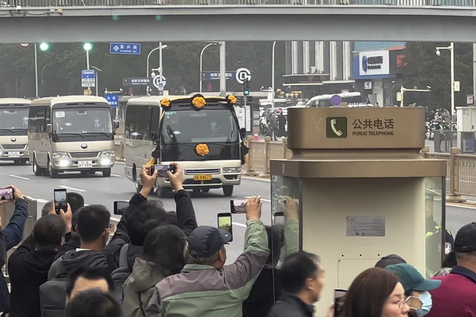 People use their smartphones to film a vehicle with flowers which is believed to be carrying the body of former Premier Li Keqiang as the convoy heads to the Babaoshan Revolutionary Cemetery in Beijing Thursday, Nov. 2, 2023. Hundreds, possibly thousands, of people gathered near a state funeral home Thursday as former Premier Li Keqiang was being put to rest. (AP Photo)