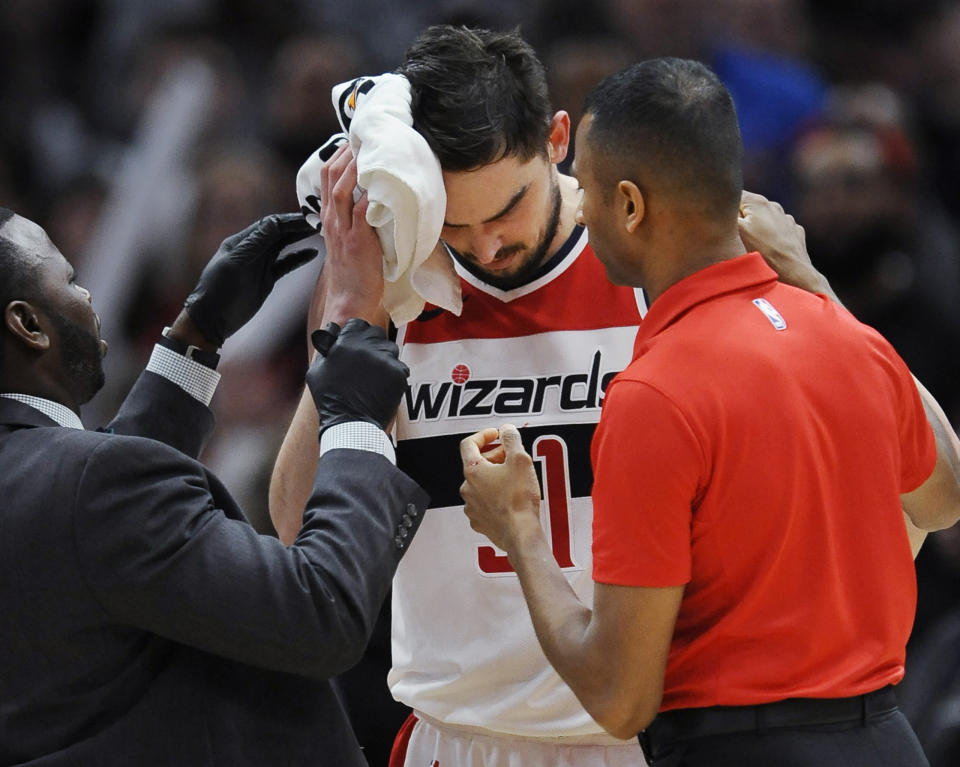 Wizards’ Tomas Satoransky is tended to after being injured when fouled by Bulls’ Bobby Portis during the final minutes of an NBA basketball game Saturday, Feb. 10, 2018, in Chicago. (AP)