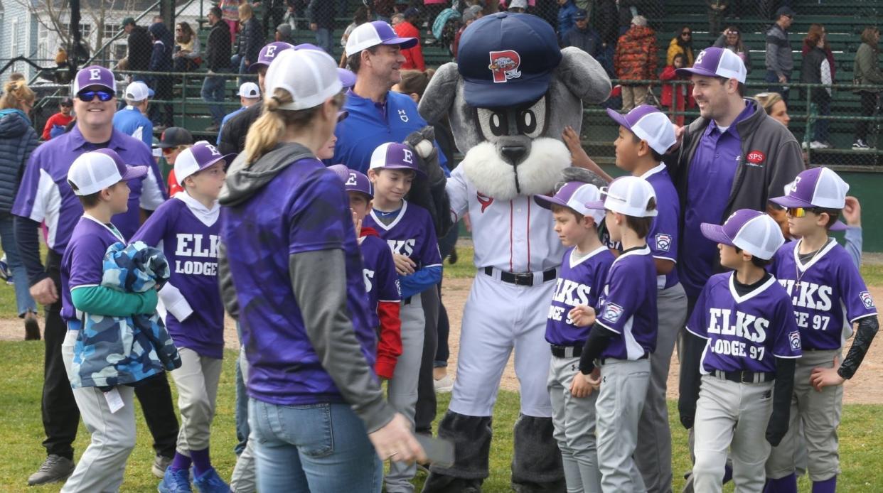 The Elk's Little League team posing with Portsmouth Little League mascot, 'Slugger', on Saturday during Opening Day.