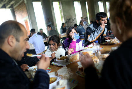 Migrants eat in a dorm destroyed during the Bosnian 1992-1995 war, in Bihac, Bosnia and Herzegovina, May 11, 2018. REUTERS/Dado Ruvic