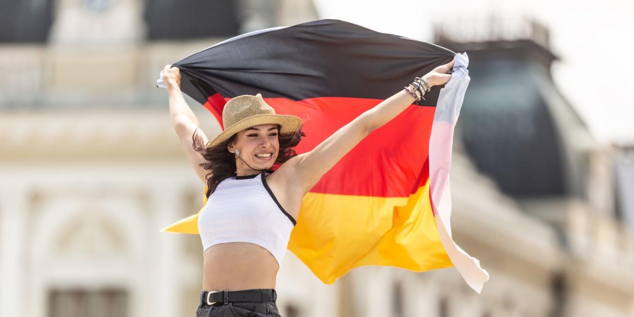 german girl emotionally waving with the national flag of germany
