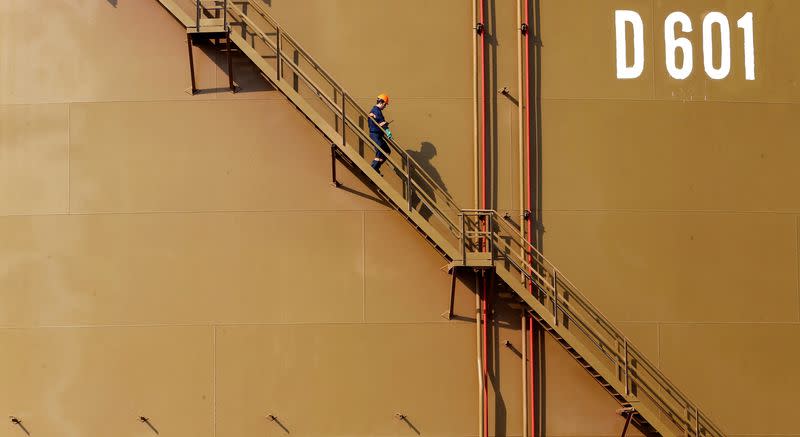 FILE PHOTO: A worker walks down the stairs of an oil tank at Turkey's Mediterranean port of Ceyhan