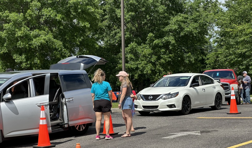 Cars enter the recovery site at Randolph Howell Elementary to collect supplies on Friday, May 10, 2024 in Columbia, Tenn.