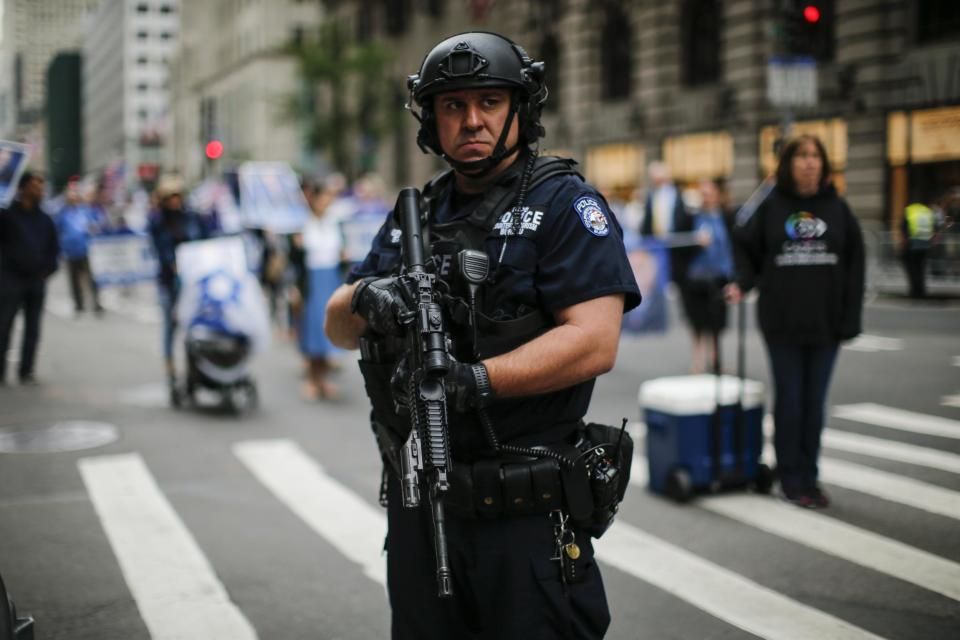 An armed NYPD officer stands guard during a parade in New York City in June: Getty/Kena Betancur