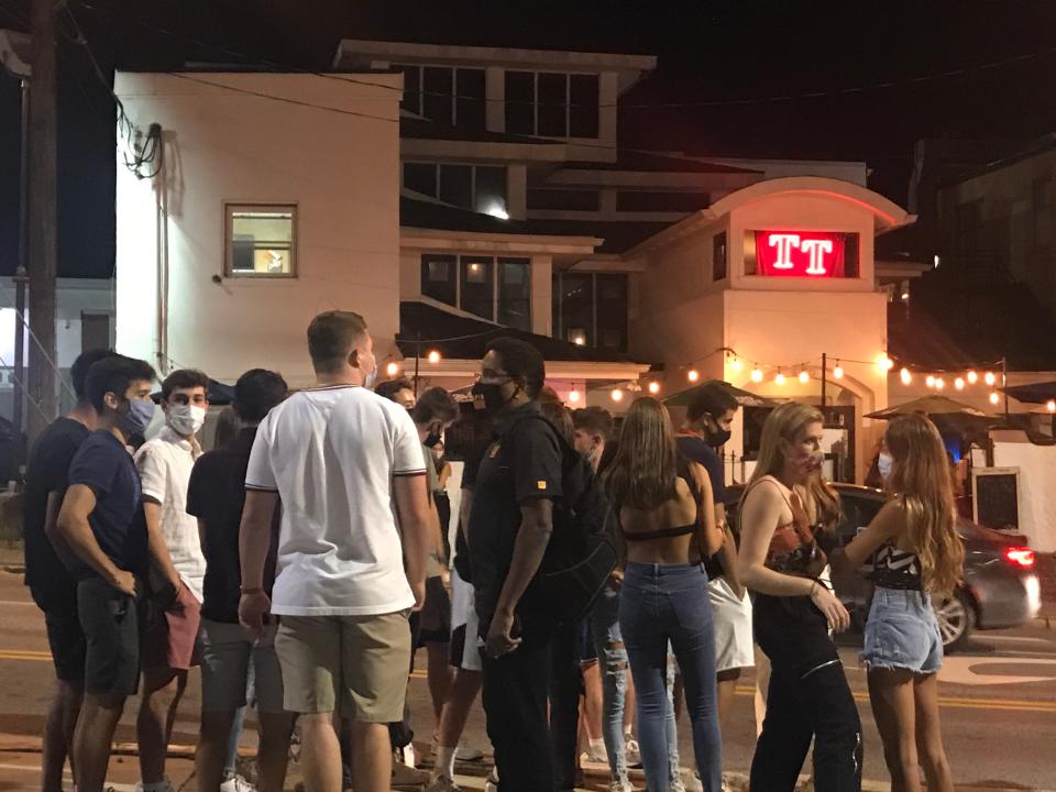 "Put your masks on!" a student called when University of Maryland President Darryll Pines, center, wearing black, stopped by a gathering near campus on Friday night.