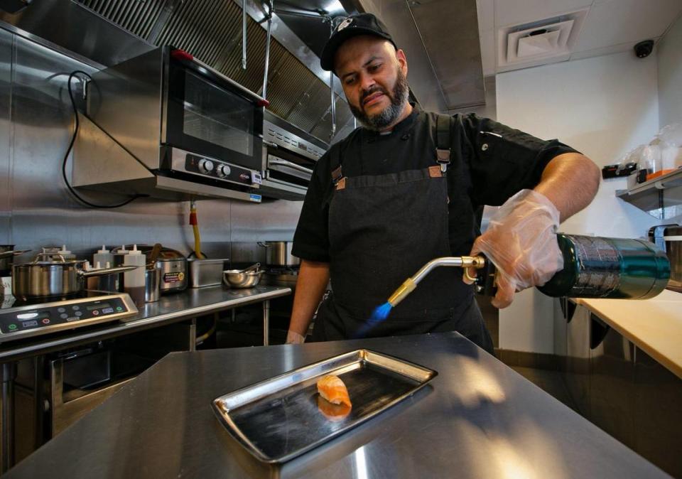 El chef Francisco Bartillo preparando un nigiri de salmón quemado en el recién inaugurado restaurante de sushi Belly Fish, en los apartamentos CORE Link de la estación de metro de Douglas Road, centro neurálgico de un nuevo y ajetreado vecindario urbano.