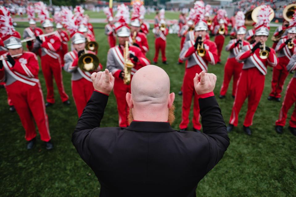 Canton South marching band director Matt Stemple leads the band in warmups shortly before kickoff against Dover, Friday, Aug. 25 at Clyde Brechbuhler Stadium in Canton.