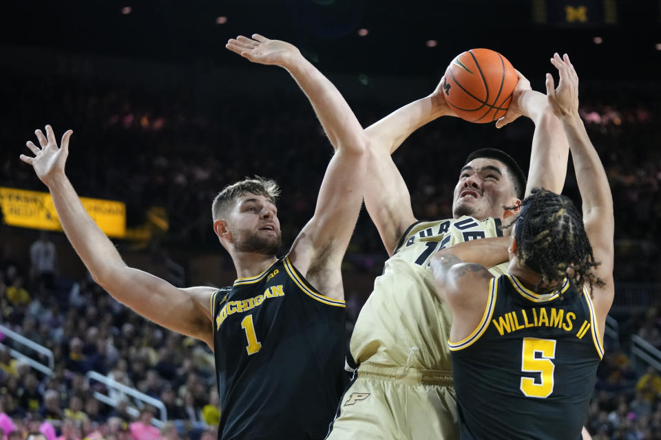 Purdue center Zach Edey, center, shoots between Michigan center Hunter Dickinson (1) and forward Terrance Williams II (5) during the first half of an NCAA college basketball game in Ann Arbor, Mich., Thursday, Jan. 26, 2023. (AP Photo/Paul Sancya)