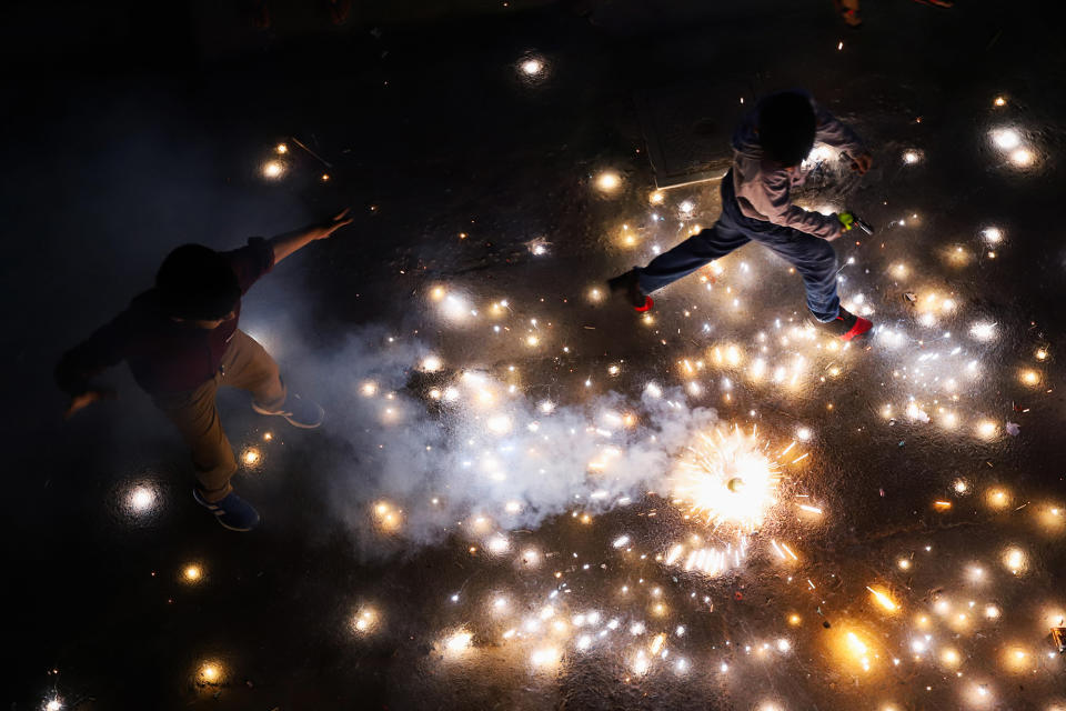 two people run in the dark throughfirecrackers