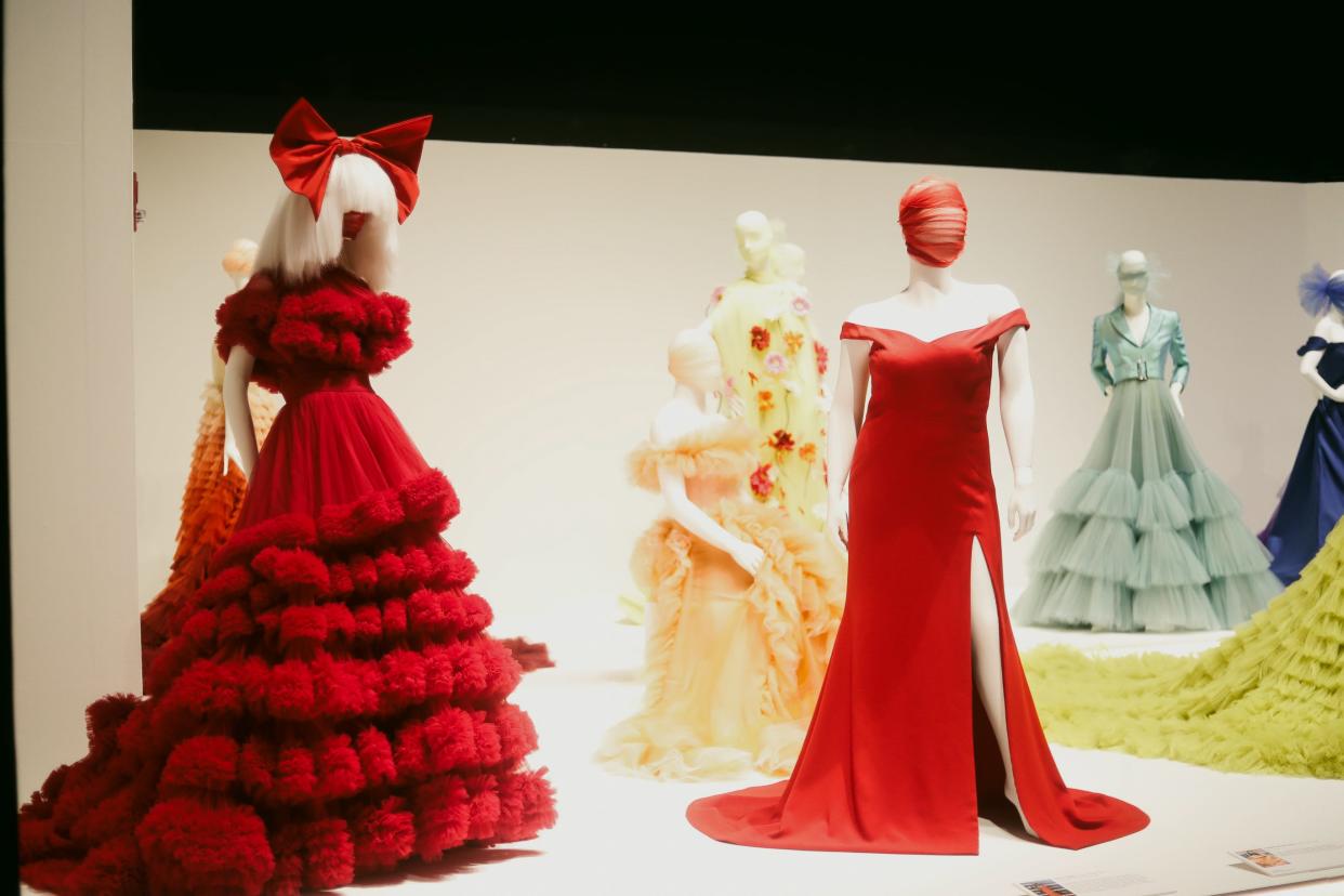 This gown (left), worn by the singer-songwriter Sia for InStyle magazine, is displayed in the new "Christian Siriano: People Are People" exhibit at the Memphis Brooks Museum of Art on Thursday, March 21, 2024, in Memphis, Tenn. The exhibit is devoted to the work of Siriano, a noted fashion designer and "Project Runway" alumnus.