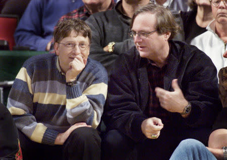 Microsoft co-founders Bill Gates (L) and Paul Allen (R) chat at courtside during the NBA game between the Seattle SuperSonics and the Portland Trailblazers at Key Arena in Seattle, March 11, 2003. REUTERS/Anthony P. Bolante/Files