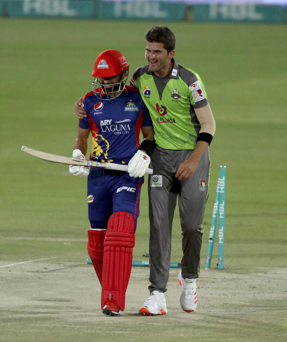 Karachi Kings' Babar Azam, left, and Lahore Qalandar's Shaheen Afridi, smile after his dismissal during a Pakistan Super League T20 cricket match between Karachi Kings and Lahore Qalandars at the National Stadium, in Karachi, Pakistan, Sunday, Feb. 28, 2021. (AP Photo/Fareed Khan)