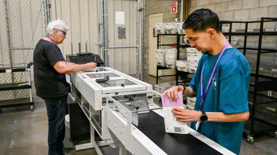 Elections office workers Cheryl Chappell and Jesus Diaz process ballots through a bar code scanner at the Fresno County Elections Department warehouse in Fresno. Fresno County had its second-lowest voter turnout since at least 1982 for a midterm primary election in the June 7, 2022 primary.