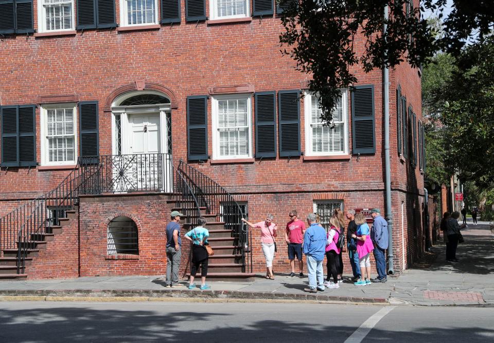 A tour group stops outside the Isaiah Davenport House Museum during a walking tour.