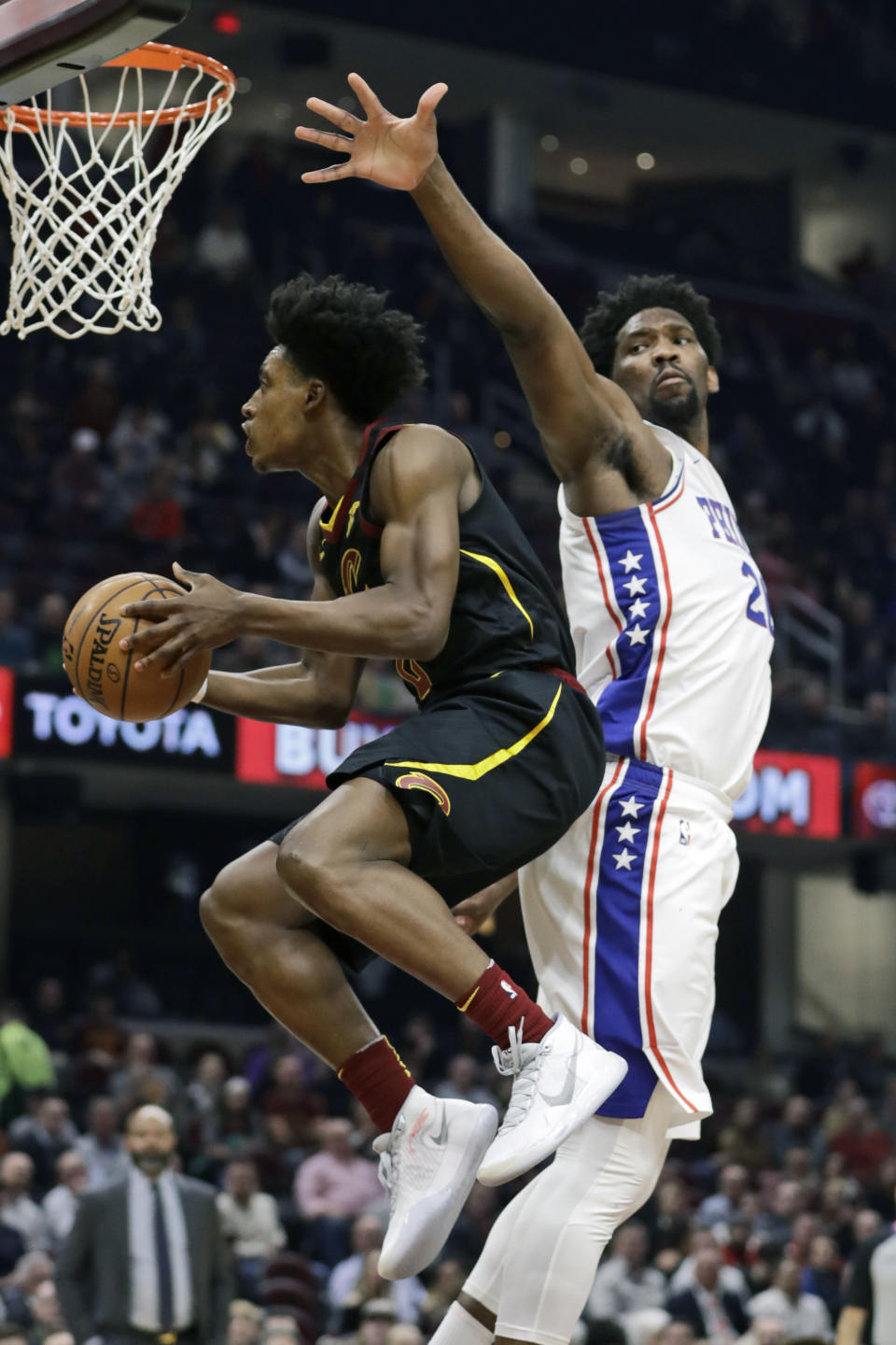 Cleveland Cavaliers' Collin Sexton, left, drives to the basket against Philadelphia 76ers' Joel Embiid in the first half of an NBA basketball game, Wednesday, Feb. 26, 2020, in Cleveland. (AP Photo/Tony Dejak)