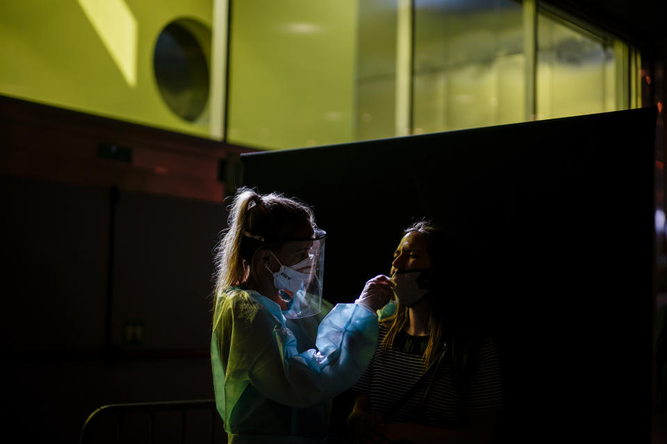 A health worker takes a swab sample collection for a COVID-19 Antigen test ahead of the Cruilla music festival in Barcelona, Spain, Friday, July 9, 2021. (AP Photo/Joan Mateu)