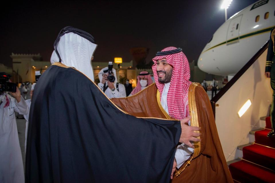 In this photo released by Saudi Royal Palace, Saudi Crown Prince Mohammed bin Salman, right, is greeted by Qatar's Emir Sheikh Tamim bin Hamad Al Thani upon his arrival at Doha airport in Qatar late Wednesday, Dec. 8, 2021. Saudi Arabia's crown prince is in Qatar for the first time since the kingdom rallied other Arab states to end their years-long rift and embargo on the tiny Gulf state. (Bandar Aljaloud/Saudi Royal Palace via AP)