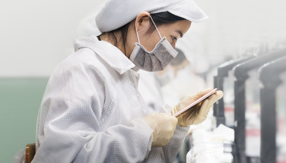 Chinese worker inspecting an iPhone