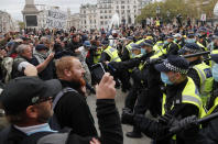 Riot police face protesters who took part in a 'We Do Not Consent' rally at Trafalgar Square, organised by Stop New Normal, to protest against coronavirus restrictions, in London, Saturday, Sept. 26, 2020. (AP Photo/Frank Augstein)