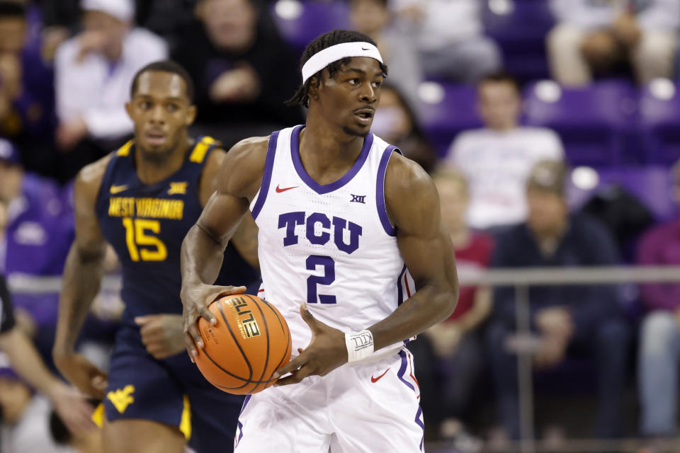 TCU forward Emanuel Miller prepares to make a pass as West Virginia's Jimmy Bell Jr. (15) defends in the first half of an NCAA college basketball game, Tuesday, Jan. 31, 2023, in Fort Worth, Texas. (AP Photo/Ron Jenkins)