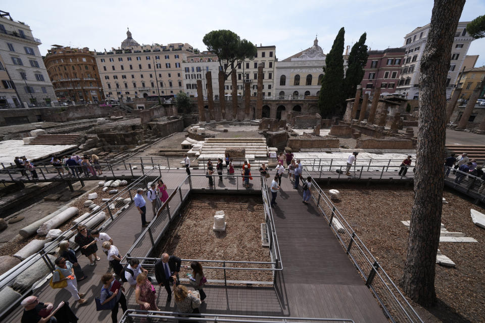 Journalists visit the new walkways of the so called 'Sacred Area' where four temples, dating back as far as the 3rd century B.C., stand smack in the middle of one of modern Rome's busiest crossroads, Monday, June 19, 2023, With the help of funding from Bulgari, the luxury jeweler, the grouping of temples can now be visited by the public that for decades had to gaze down from the bustling sidewalks rimming Largo Argentina (Argentina Square) to admire the temples below where Julius Caesar masterminded his political strategies and was later fatally stabbed in 44 B.C. (AP Photo/Domenico Stinellis)