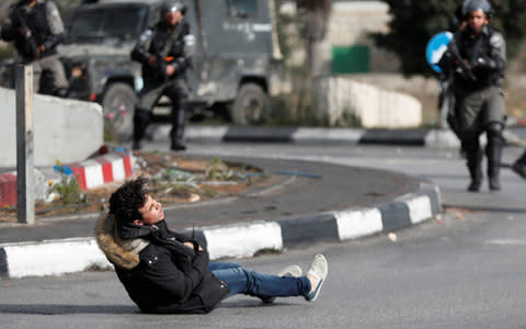 Israeli border policemen stand away after shooting the man - Credit:  GORAN TOMASEVIC/REUTERS