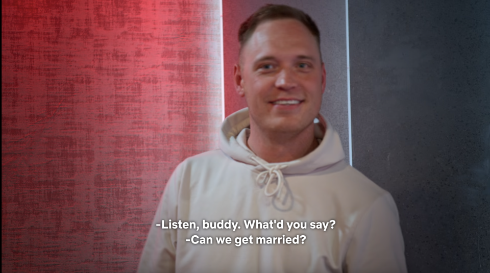 Man in hoodie smiling with subtitles "Listen, buddy. What you say? Can we get married?"