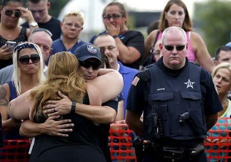 Mel Gliniewicz (front L), wife of slain Fox Lake Police Lieutenant Charles Joseph Gliniewicz hugs a police officer at a vigil in Fox Lake, Illinois, United States, September 2, 2015. REUTERS/Jim Young
