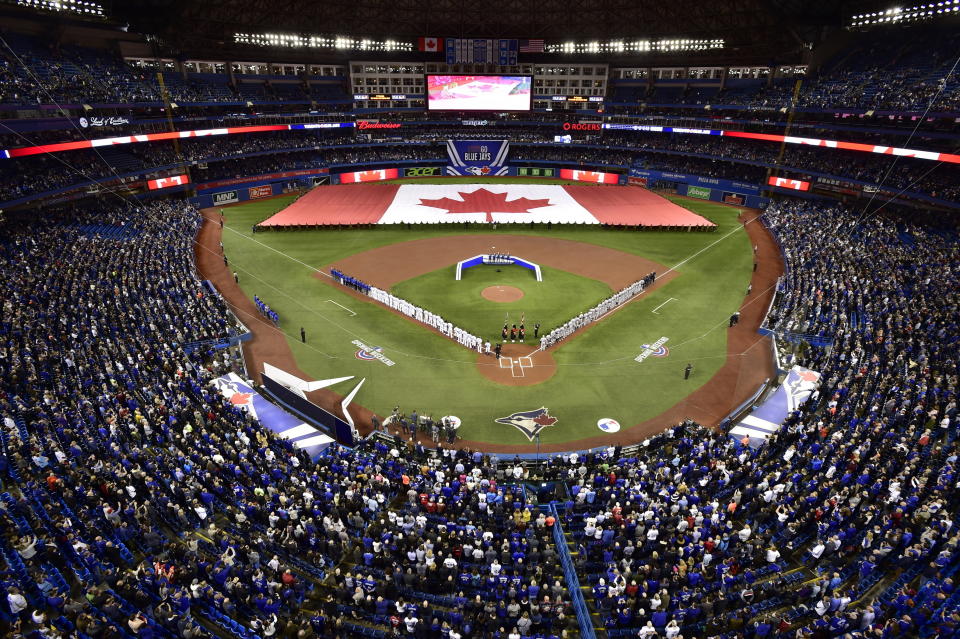 FILE - Members of the Toronto Blue Jays and the Detroit Tigers lineup before an opening day baseball game at Rogers Centre in Toronto, in this Thursday, March 28, 2019, file photo. Talks between the Toronto Blue Jays and the Canadian government have accelerated significantly and an exemption on border restrictions that would allow them to play in Canada starting July 30 may be possible, an official familiar with the talks told The Associated Press on Friday, July 16, 2021. (Frank Gunn/The Canadian Press via AP, File)