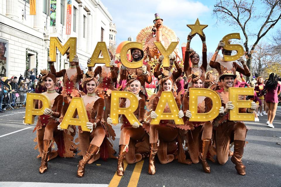 Dancers dressed in fall colors and held up letters that spelled out "Macy's Parade" in N.Y.C.'s Manhattan neighborhood.