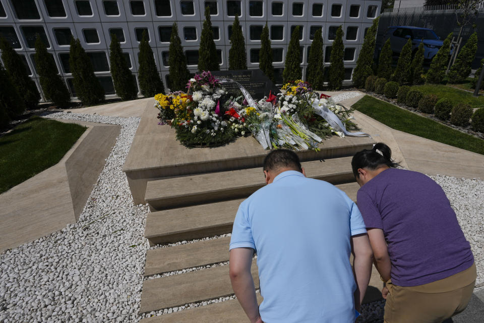 Visitors from China take a bow in front of a black-marble monument and to lay flowers in honor of the victims of the 1999 bombing, in Belgrade, Serbia, Saturday, May 4, 2024. Chinese leader Xi Jinping's visit to European ally Serbia on Tuesday falls on a symbolic date: the 25th anniversary of the bombing of the Chinese Embassy in Belgrade during NATO's air war over Kosovo. (AP Photo/Darko Vojinovic)