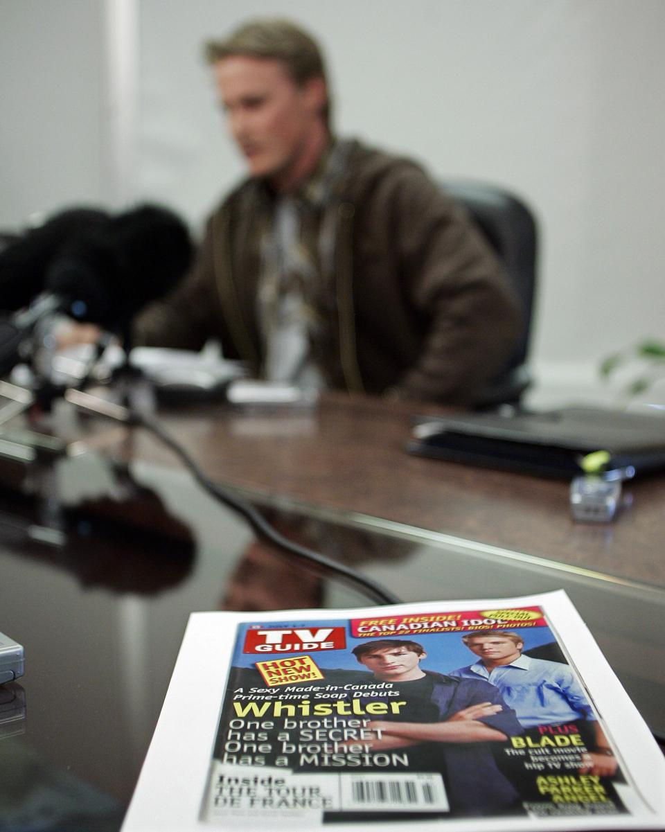 A copy of a cover of TV Guide promoting the CTV program “Whistler” sits on a boardroom table as Ross Rebagliati reads his statement of claim against the television network and the producers of the show during a press conference in Vancouver on August 2, 2006. Rebagliati is upset that the show misappropriates and defames his character. (CP PHOTO/Richard Lam)