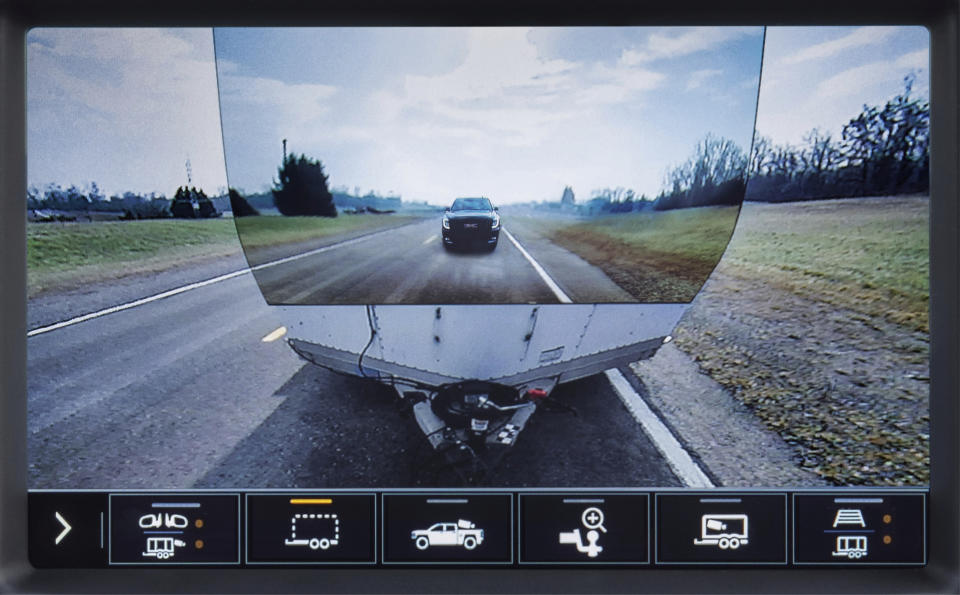 This image provided by General Motors, shows the display of a 2020 GMC Sierra HD feature called Transparent Trailer, one of the few pickup trucks that provides an image of the road behind a trailer. This optional feature uses augmented reality to project an image of the road on the front of a trailer, giving the illusion of a transparent trailer. (General Motors via AP)