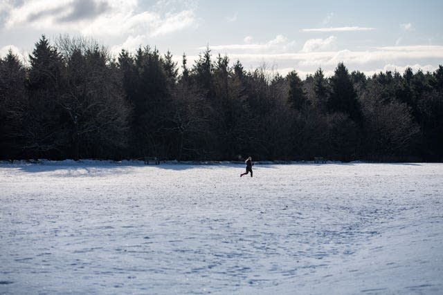 A runner navigates snow and ice at Lickey Hills Country Park in Birmingham 