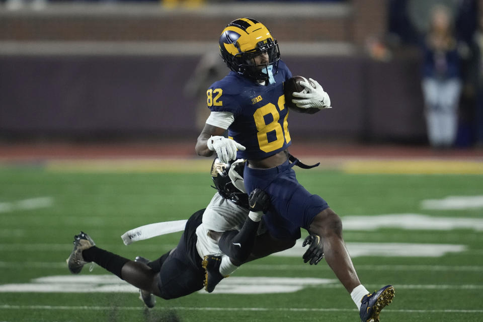 Michigan wide receiver Semaj Morgan (82) runs after a catch as Purdue defensive back Sanoussi Kane (21) in the second half of an NCAA college football game in Ann Arbor, Mich., Saturday, Nov. 4, 2023. (AP Photo/Paul Sancya)