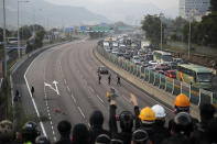 A pro-democracy protester cheers on a bridge as they block a road outside the campus of the Chinese University of Hong Kong, in Hong Kong, Wednesday, Nov. 13, 2019. Protesters in Hong Kong battled police on multiple fronts on Tuesday, from major disruptions during the morning rush hour to a late-night standoff at a prominent university, as the 5-month-old anti-government movement takes an increasingly violent turn. (AP Photo/Kin Cheung)