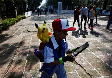 A child carries a Pokemon character, Pikachu, on his shoulder as he plays Pokemon Go during a gathering to celebrate "Pokemon Day" in Mexico City, Mexico August 21, 2016. REUTERS/Carlos Jasso