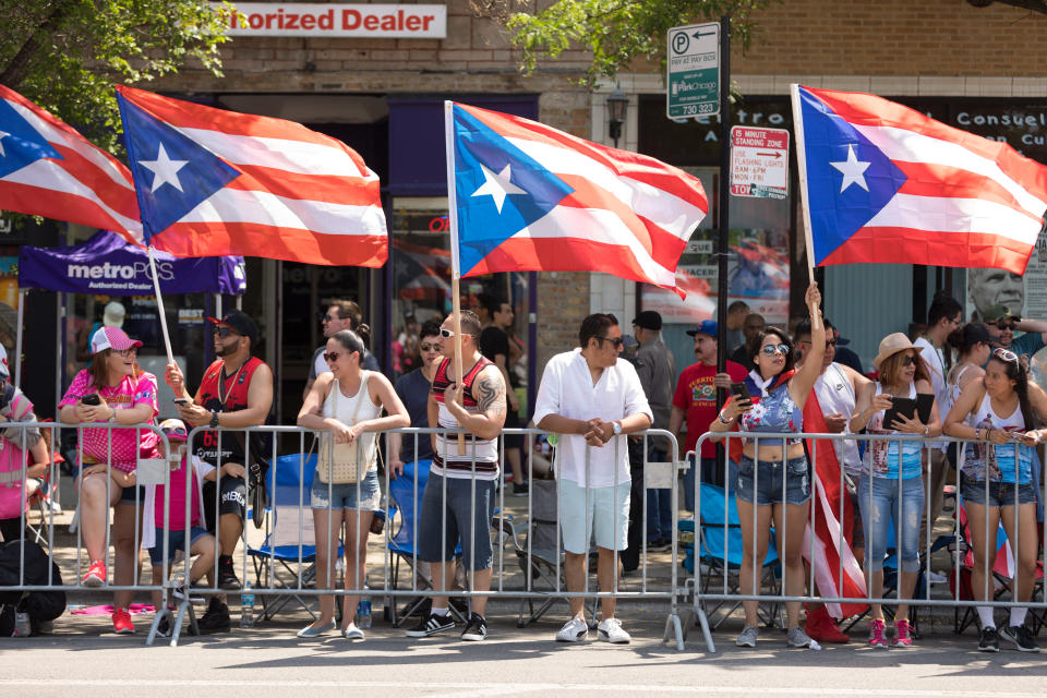 Espectadores con banderas de Puerto Rico en el desfile boricua de Chicago. (AP)