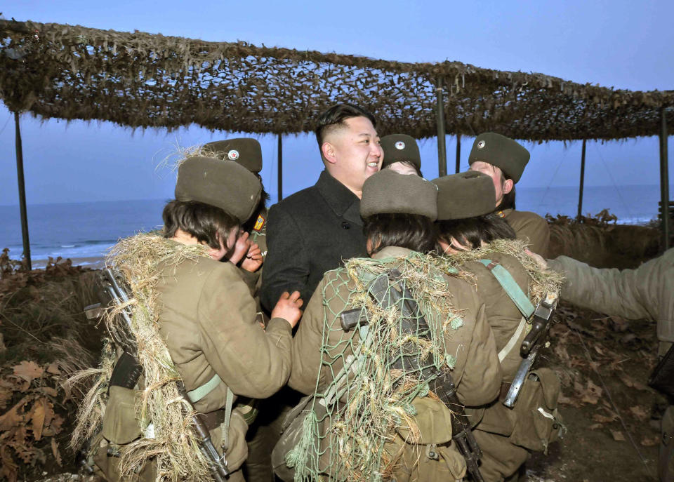 This picture released by North Korea's official Korean Central News Agency on March 26, 2013 and taken on March 25, 2013 shows North Korean leader Kim Jong-Un (C) speaking with female artilleries during his inspection of the landing and anti-landing drills of KPA Large Combined Units 324 and 287 and KPA Navy Combined Unit 597 at an undisclosed location on North Korea's east coast.