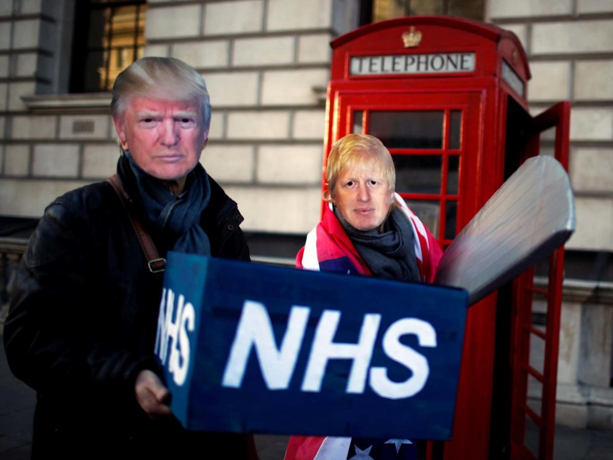 Healthcare professionals dressed as Boris Johnson and Donald Trump attend a demonstration demanding the NHS be protected from commercial exploitation: Reuters