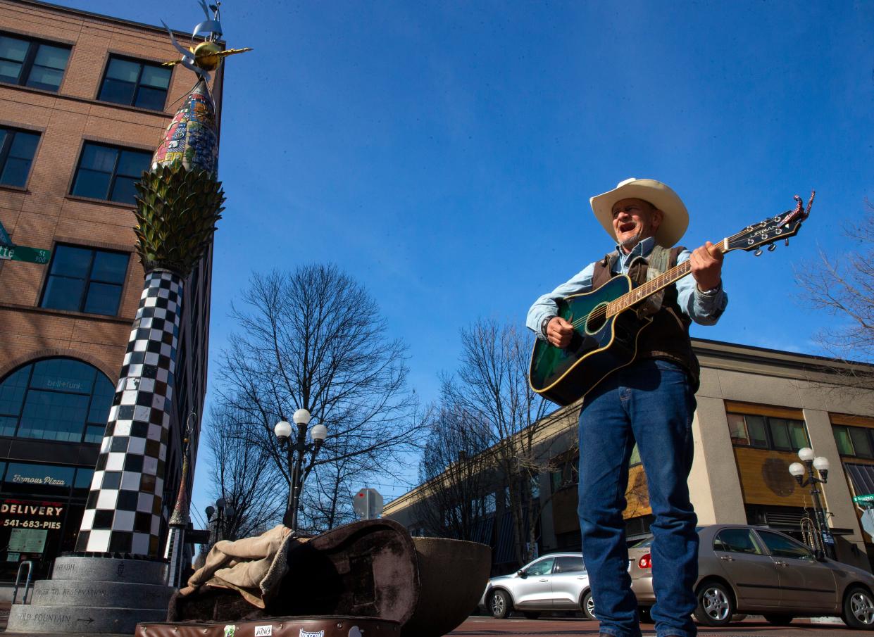 Thomas Green takes advantage of the nice weather to play his guitar for tips at Kesey Square in Eugene on Wednesday, Feb. 9. 2022.