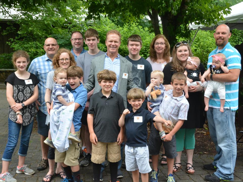 The Johnson, Gardner and Hefner families pose for a photograph wearing name badges.