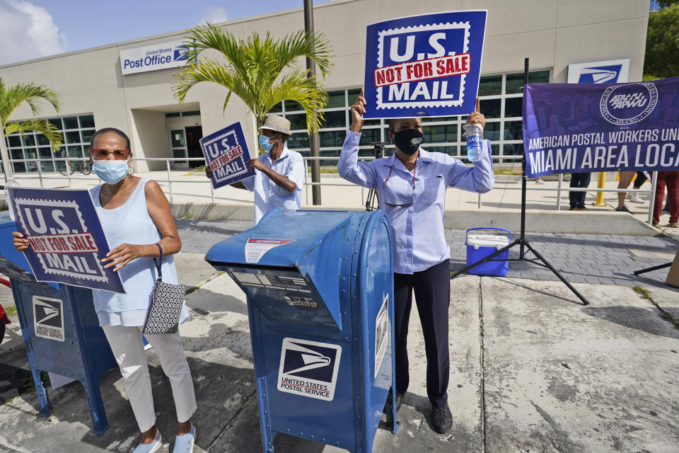 Protesters demonstrate during a "National Day of Action to Save the "Peoples" Post Office!" outside the Flagler Station post office, Tuesday, Aug. 25, 2020, in Miami. The pandemic has pushed the Postal Service into a central role in the 2020 elections, with tens of millions of people expected to vote by mail rather than in-person. At the same time, Trump has acknowledged he is withholding emergency aid from the service to make it harder to process mail-in ballots, as his election campaign legally challenges mail voting procedures in key states. (AP Photo/Wilfredo Lee)