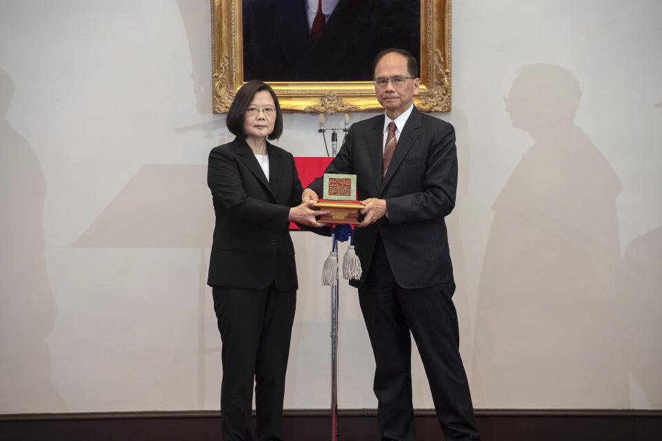 In this photo released by the Taiwan Presidential Office, Taiwanese President Tsai Ing-wen, left, holds up a seal with Parliament top speaker You Shi-kun during an inauguration ceremony at the Presidential office in Taipei, Taiwan on Wednesday, May 20, 2020. Tsai has been inaugurated for a second term amid increasing pressure from China on the self-governing island democracy it claims as its own territory. (Taiwan Presidential Office via AP)