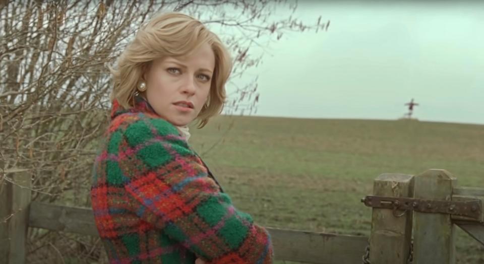 Kristen Stewart stands by a field in a green and red blazer