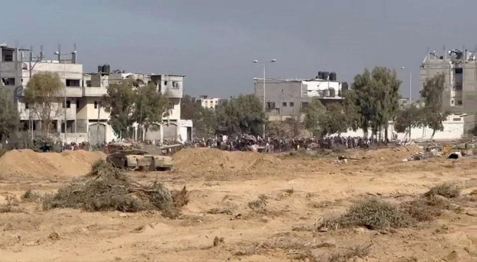 PHOTO:A still image taken from a video shows what the Israeli army says are Palestinians holding white flags as they walk from north Gaza to the south near an Israeli tank in a location given as Gaza, obtained by Reuters on Nov. 7, 2023. (Israeli Defense Forces via Reuters)