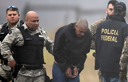 Federal Police agents escort Adelio Bispo de Oliveira, suspected of stabbing Brazilian presidential candidate Jair Bolsonaro, to transfer him to a federal prison in Campo Grande, Mato Grosso state, at Francisco Alvares de Assis airport in Juiz de Fora, Brazil, September 8, 2018. REUTERS/Ricardo Moraes